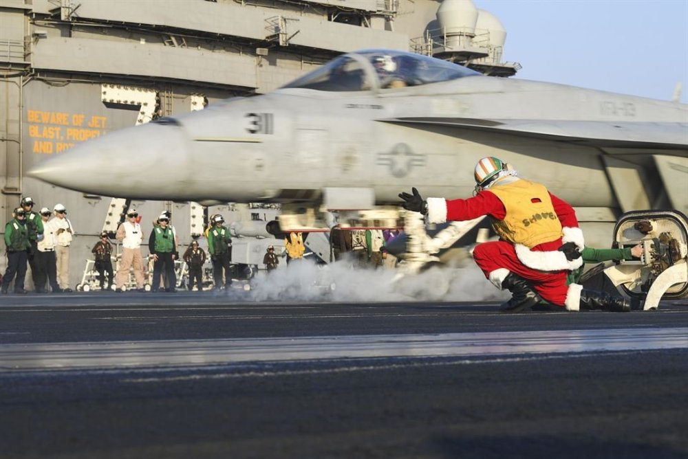 Navy-Lt.-Larry-Young-dressed-as-Santa-Claus-signals-to-launch-an-FA-18-E-Super-Hornet-on-the-flight-deck-of-the-USS-Theodore-Roosevelt.jpg